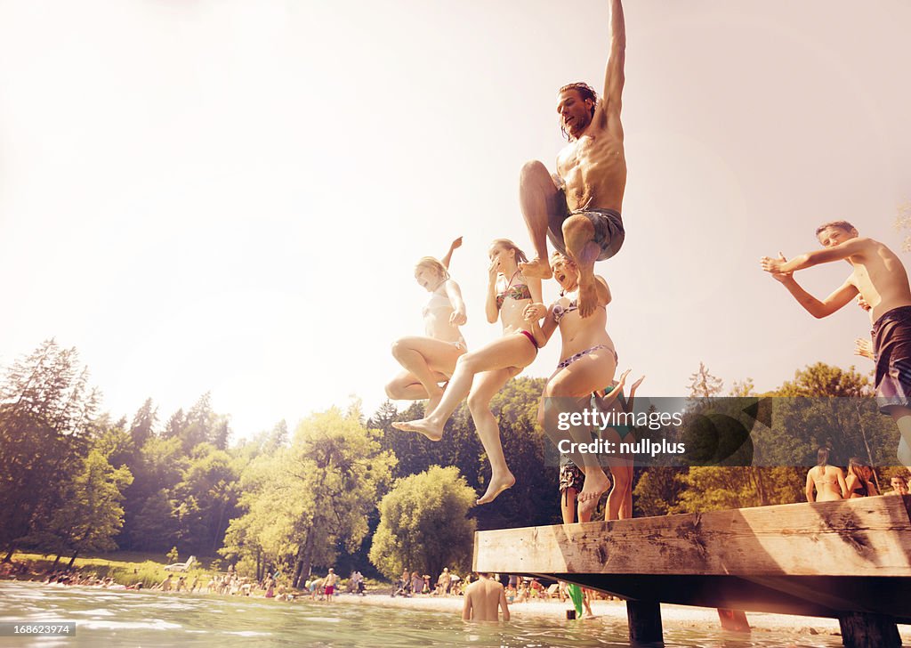 Friends jumping into the water