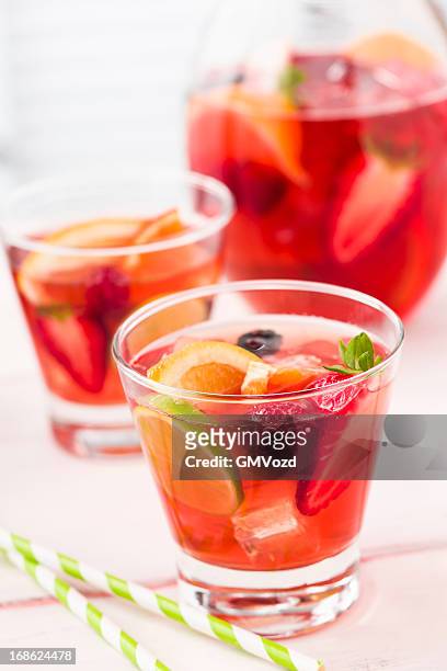 fruit punch with strawberries, raspberries orange and lime - punch stock pictures, royalty-free photos & images
