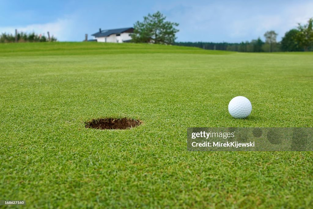 Golf, ball lying on the green next to hole