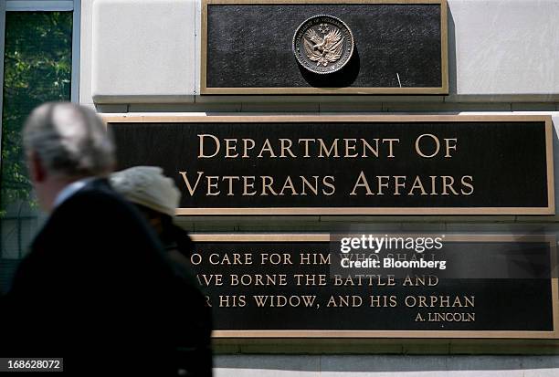 Pedestrians walk past the U.S. Department of Veterans Affairs headquarters in Washington, D.C., U.S., on Friday, May 10, 2013. The department's...