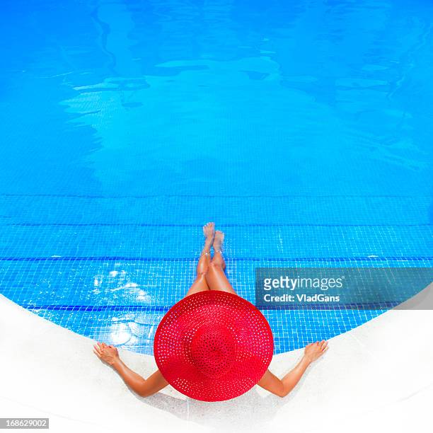 woman relaxing in a resort swimming pool - sun hat stock pictures, royalty-free photos & images