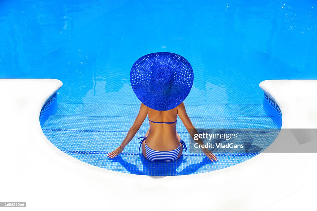 Woman relaxing in a resort swimming pool