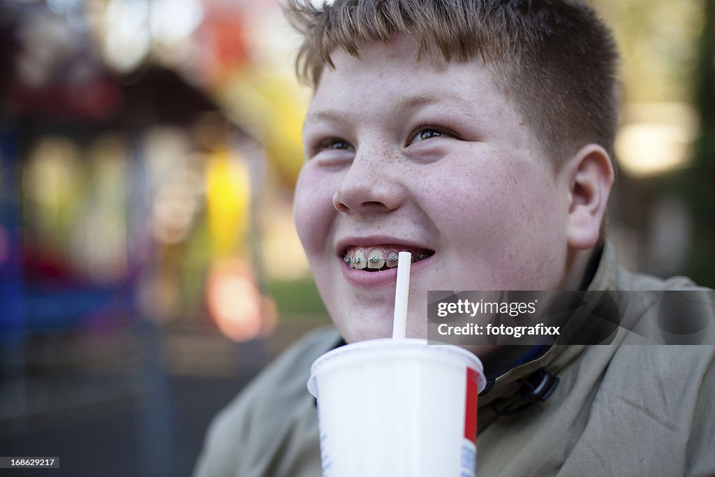 Unhealthy Eating: redhead overweight teenage boy with soft drink