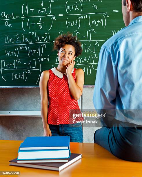 female student answering questions - two female teachers blackboard stockfoto's en -beelden