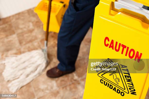 service industry:  caution sign and janitor mopping retail store floor - mop stock pictures, royalty-free photos & images