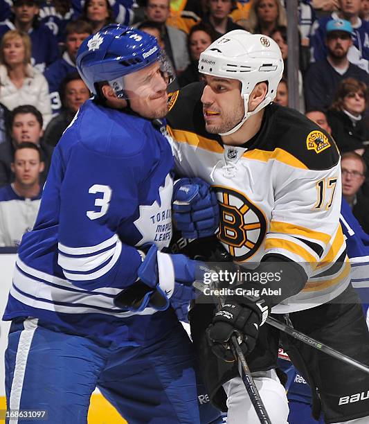 Dion Phaneuf of the Toronto Maple Leafs battles with Milan Lucic of the Boston Bruins in Game Six of the Eastern Conference Quarterfinals during the...