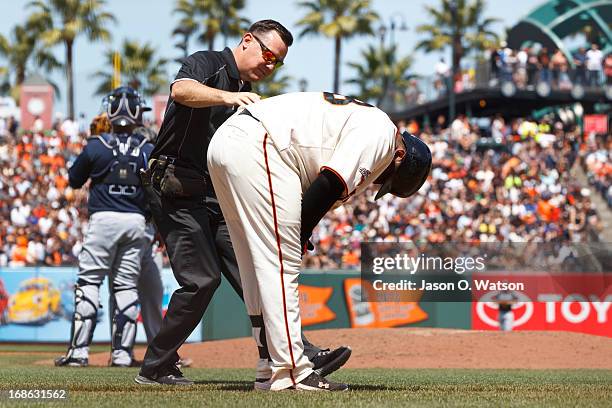 Pablo Sandoval of the San Francisco Giants is attended to by trainer Dave Groeschner after getting hit by a pitch against the Atlanta Braves during...