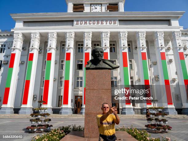 Russian visitor takes a selfie with a bust of Lenin in front of the House of Soviets building on September 1, 2023 in Tiraspol, Moldova . Tiraspol is...