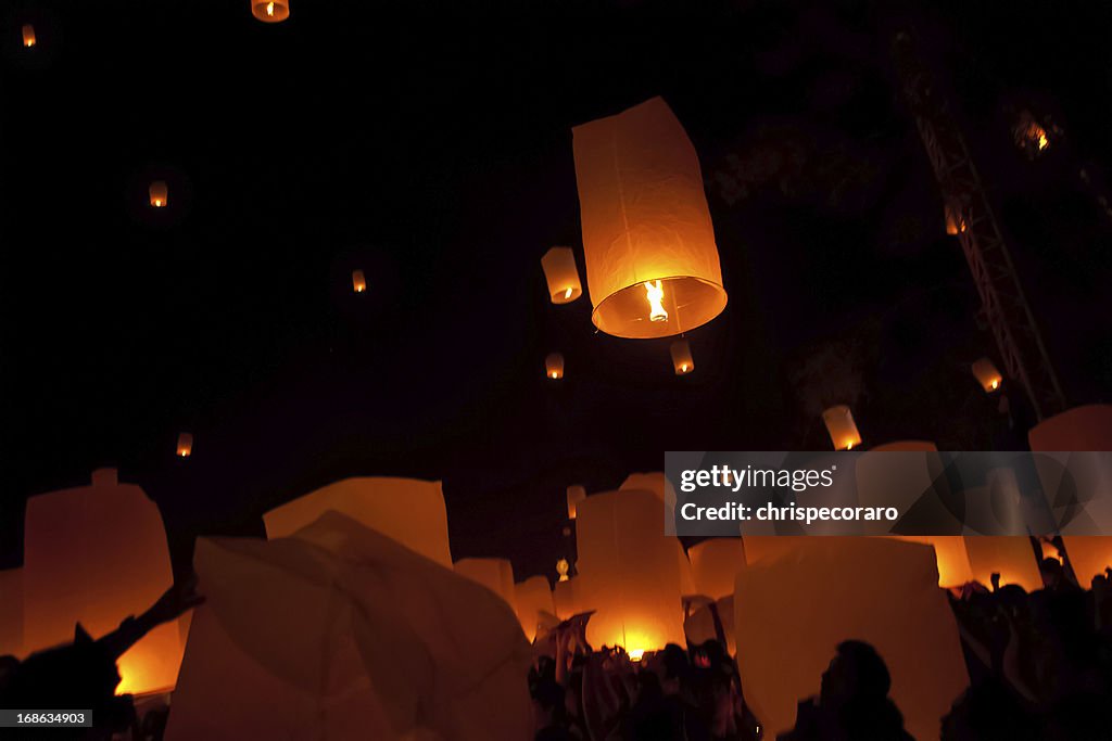 Silhouettes of people and dim lighting at Loi Krathong