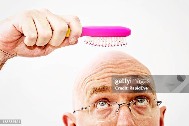 worried bald man eyes hairbrush: a pointless tool! - futility stock pictures, royalty-free photos & images