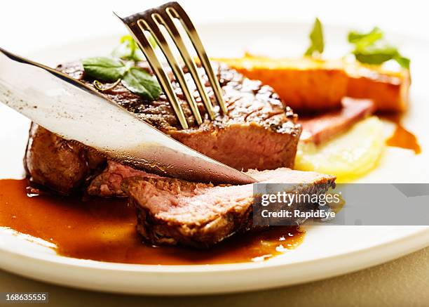 knife and fork slicing into juicy grilled fillet steak - beefsteak 2013 stock pictures, royalty-free photos & images
