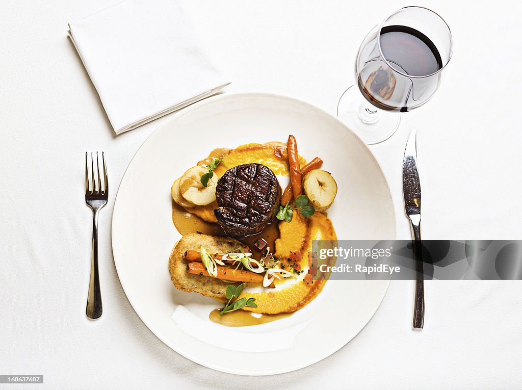 Looking down at delicious steak meal served with red wine