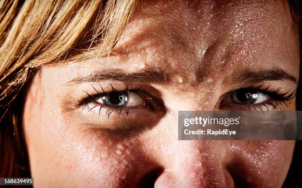 close-up of perspiring, tense, frowning young blonde woman - scared portrait stock pictures, royalty-free photos & images