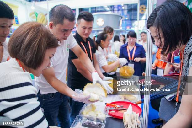 An exhibitor opens a durian at Vietnam exhibition area during the 20th China-ASEAN Expo at Nanning International Convention and Exhibition Center on...