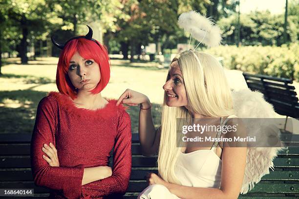 devil tempts an angel - angel funny stock pictures, royalty-free photos & images