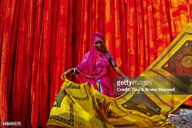 india, rajasthan, sari factory. - woman in red sari stock-fotos und bilder