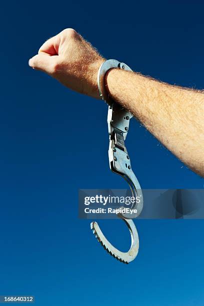 free at last! hand with clenched fist and open handcuff - bail law stock pictures, royalty-free photos & images