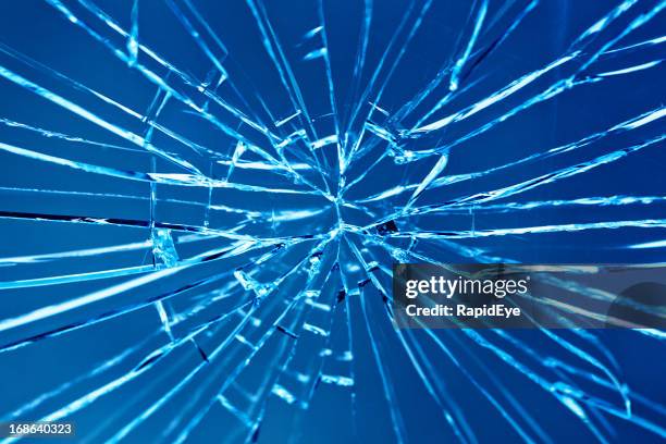 smashed window with multiple cracks against blue background - window crack stock pictures, royalty-free photos & images