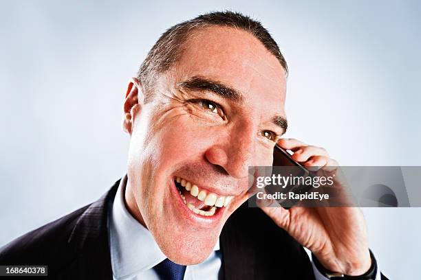 sleazy man tries too hard, giving cheesy grin on phone - cheesy salesman stockfoto's en -beelden