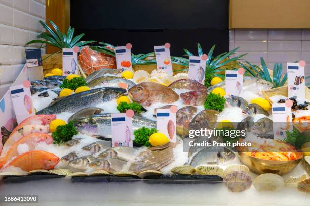 fresh seafood on ice in a fish market's oceanic bounty - étal poisson photos et images de collection