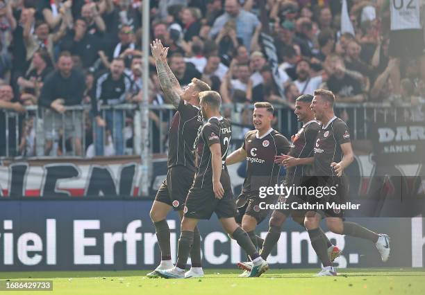 Eric Smith of FC St. Pauli celebrates with his teammates after scoring the team's second goal during the Second Bundesliga match between FC St. Pauli...