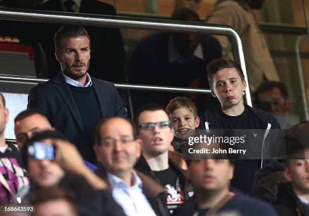 David Beckham of PSG and his sons Romeo Beckham and Brooklyn Beckham attend the Ligue 1 match between Paris Saint-Germain FC and Valenciennes FC at...