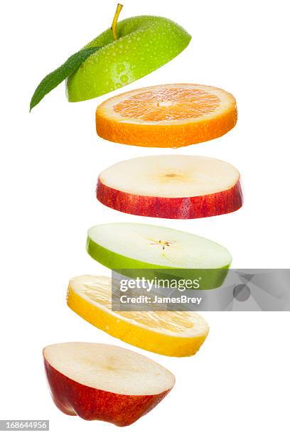 fresh fruit slices; apples, lemon, orange tossed in air - apple slice stock pictures, royalty-free photos & images