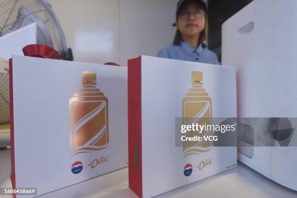 An employee stacks boxes of Baijiu-infused chocolate at a Moutai ice cream store on September 16, 2023 in Hangzhou, Zhejiang Province of China....