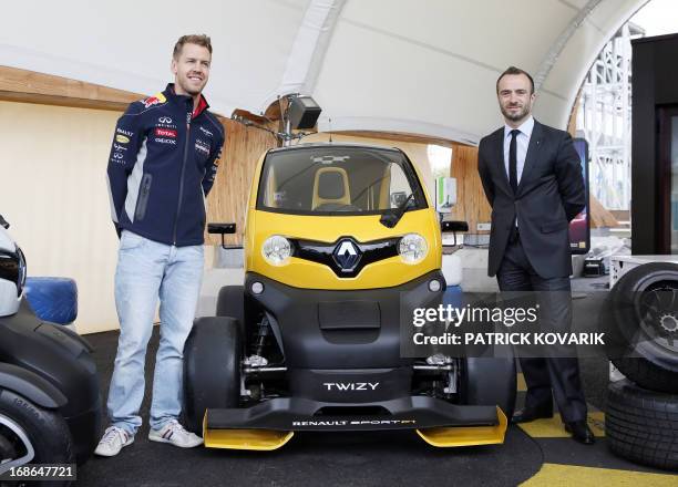 Formula One German triple world champion Sebastian Vettel pose with Renault ZE's director Benoit Treilhou next to a Renault Twizy electric car on May...