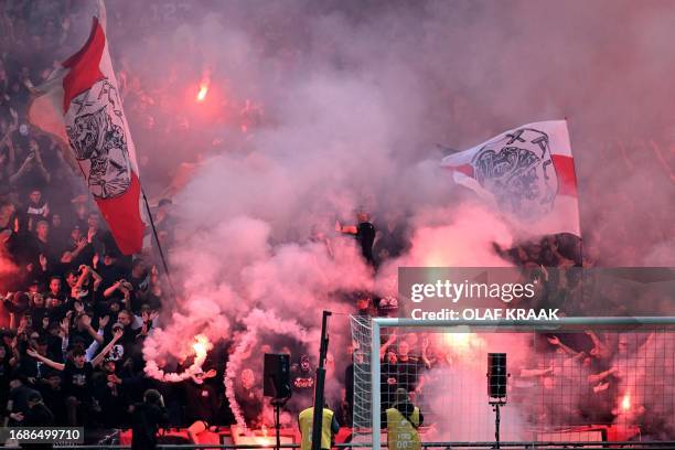 Ajax' supporters set off fireworks during the Dutch Eredivisie match between Ajax Amsterdam and Feyenoord at The Johan Cruijff ArenA in Amsterdam on...