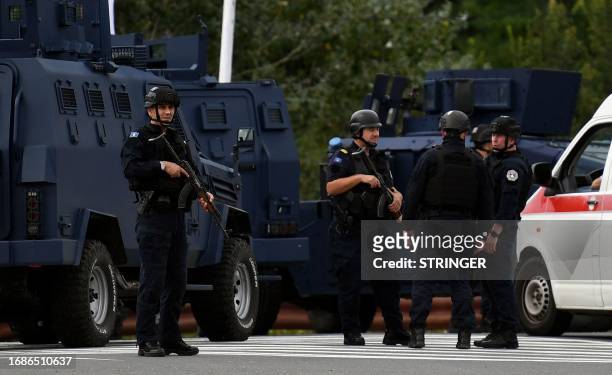 Kosovo's police officers stand guard at the entrance of the village of Banjska on September 24 after one policeman was killed and another wounded in...