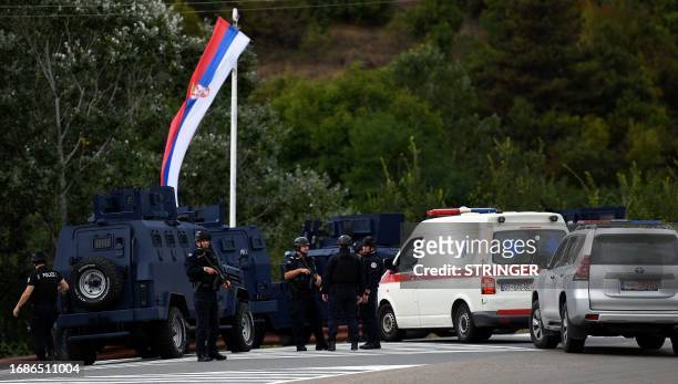 Kosovo's police officers stand guard at the entrance of the village of Banjska on September 24 after one policeman was killed and another wounded in...