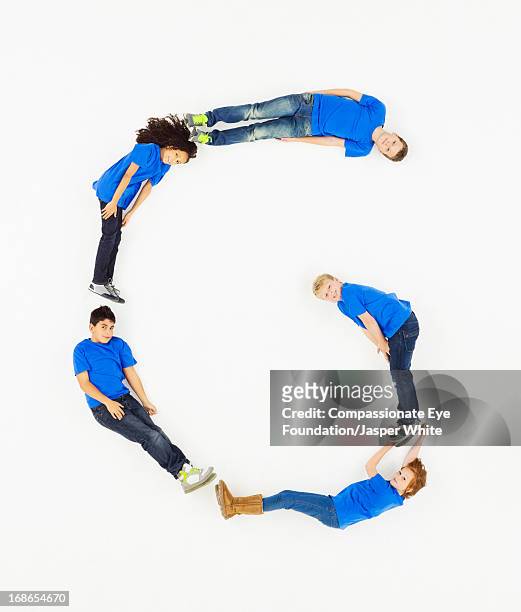 children laying in letter 'g' formation - five people stock-fotos und bilder