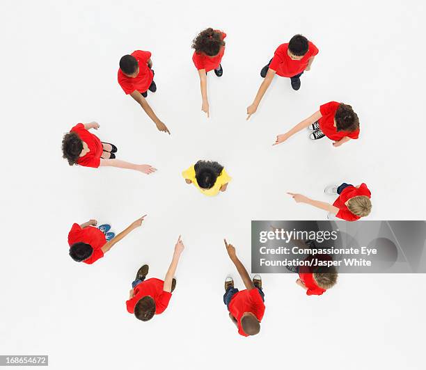 children standing in circle pointing to centre - vorwurf stock-fotos und bilder
