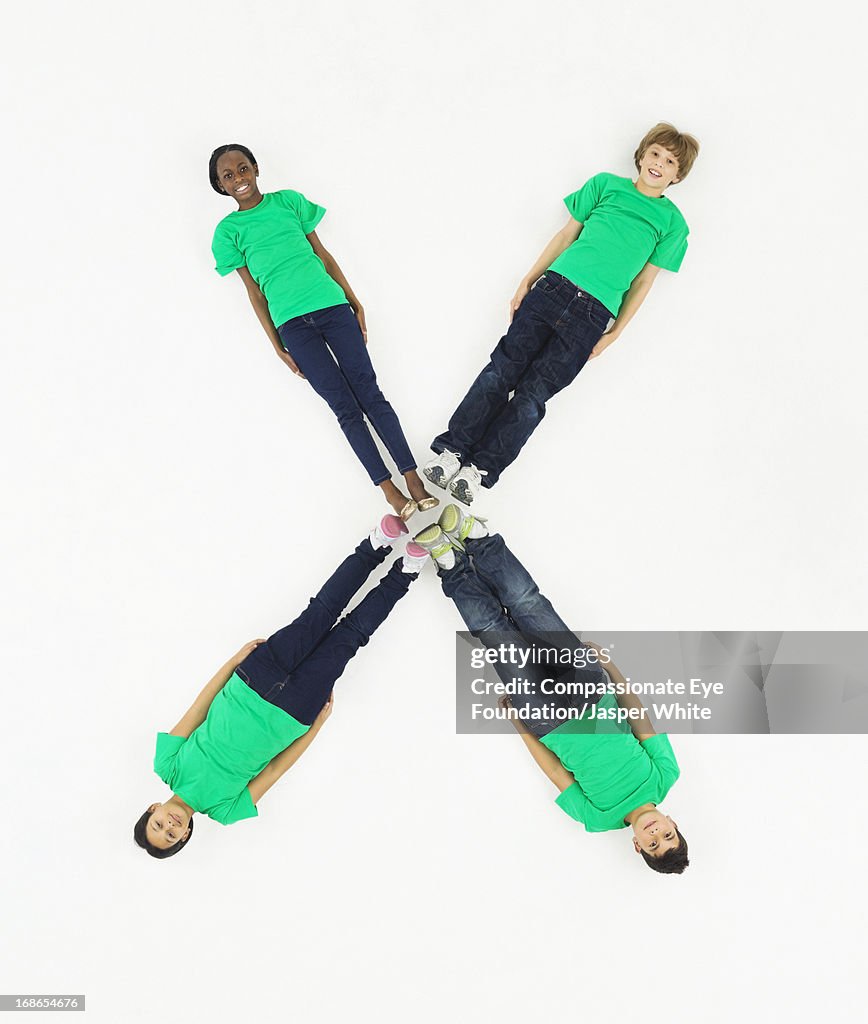 Children laying in letter 'X' formation