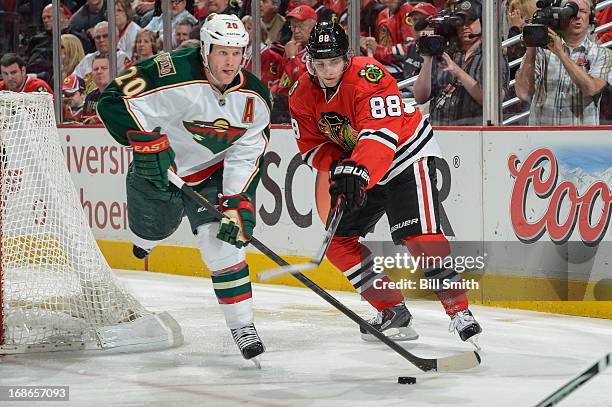 Ryan Suter of the Minnesota Wild gets ready to pass the puck as Patrick Kane of the Chicago Blackhawks reaches across to block in Game Five of the...