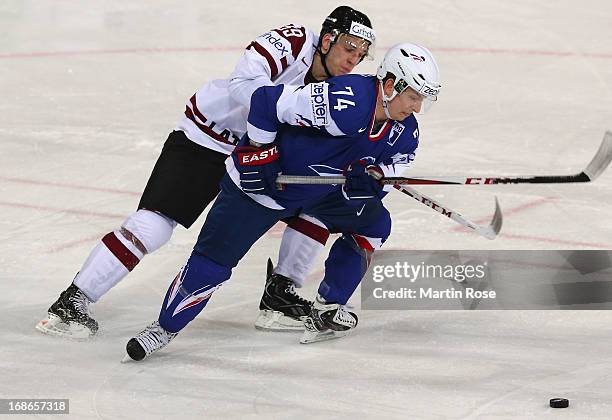 Zemgus Girgensons of Latvia and Nicolas Besch of France battle for the puck during the IIHF World Championship group H match between Latvia and...