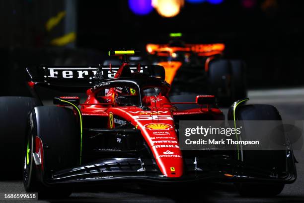 Carlos Sainz of Spain driving the Ferrari SF-23 leads Lando Norris of Great Britain driving the McLaren MCL60 Mercedes during the F1 Grand Prix of...