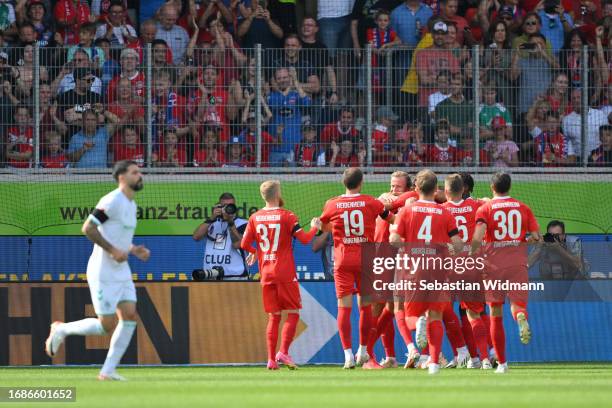 Tim Kleindienst of 1.FC Heidenheim celebrates with teammates after scoring the team's first goal from a penalty kick during the Bundesliga match...