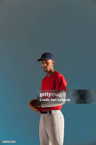 baseball player holding ball and glove - baseball player stock pictures, royalty-free photos & images