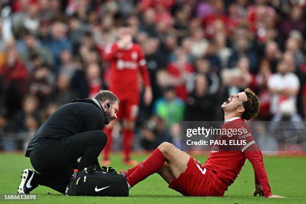 Liverpool's English midfielder Curtis Jones receives medical attention after picking up an injury during the English Premier League football match...