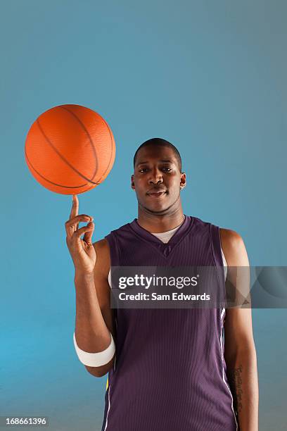 basketball player balancing ball on one finger - basketbaltenue stockfoto's en -beelden