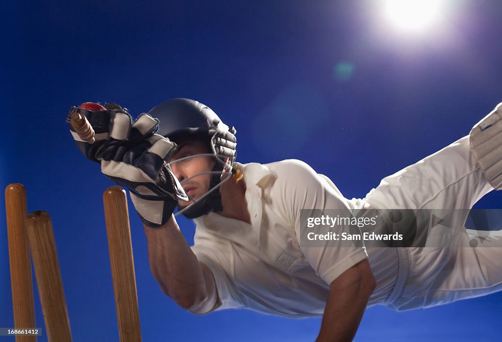 Cricket player reaching for bats