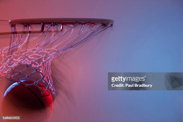 blurred view of basketball going into hoop - basketball hoop stockfoto's en -beelden