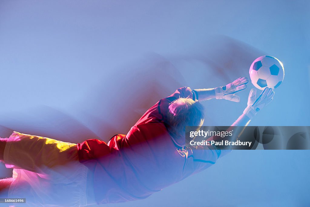 Blurred view of soccer player lunging for ball