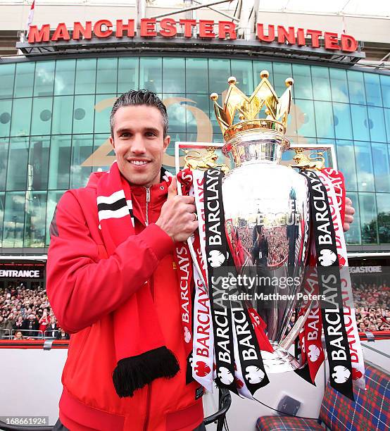 Robin van Persie of Manchester United poses with the Premier League trophy at the start of the Premier League trophy winners parade on May 13, 2013...