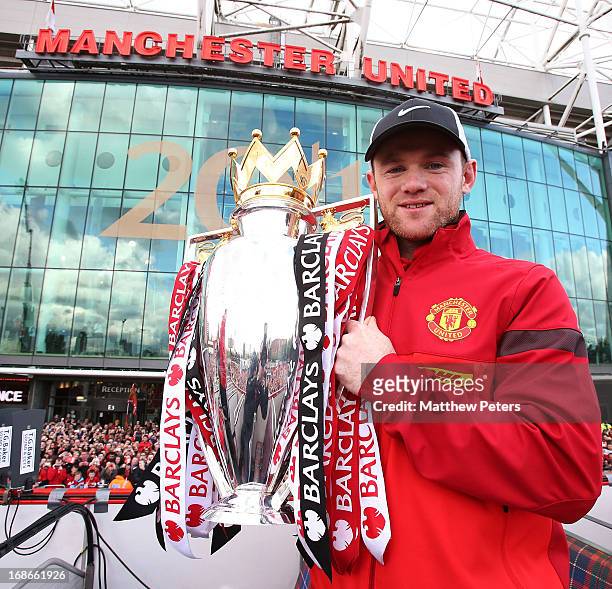 Wayne Rooney of Manchester United poses with the Premier League trophy at the start of the Premier League trophy winners parade on May 13, 2013 in...