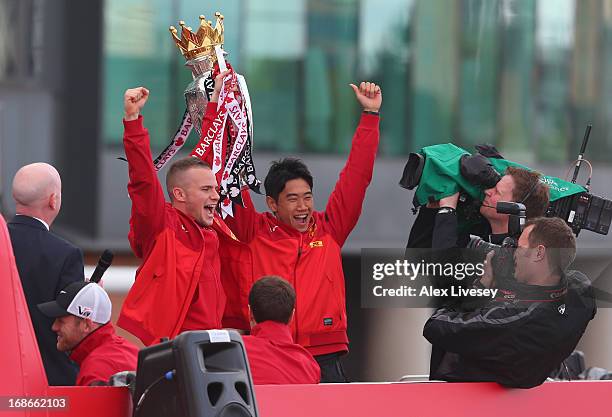 Tom Cleverley and Shinji Kagawa hold aloft the Barclays Premier League Trophy aloft on the open topped bus outside Old Trafford during the Manchester...