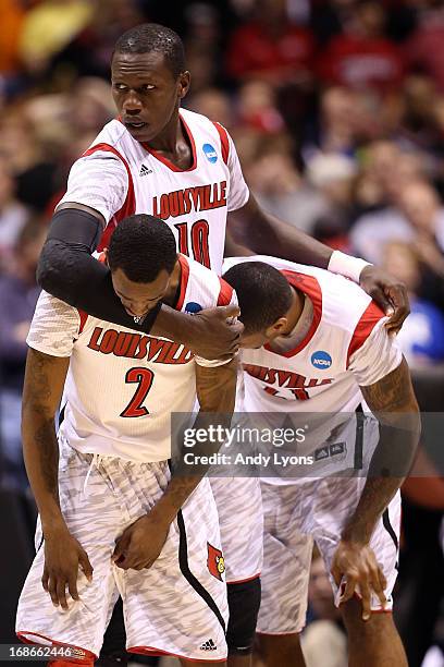 Russ Smith, Gorgui Dieng and Chane Behanan of the Louisville Cardinals react after Kevin Ware suffered a compound fracture to his leg in the first...