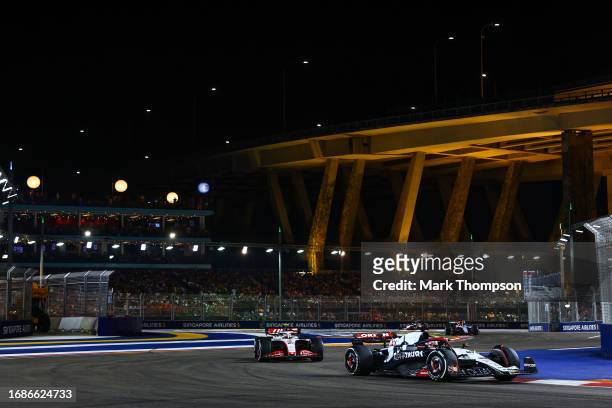 Liam Lawson of New Zealand driving the Scuderia AlphaTauri AT04 leads Nico Hulkenberg of Germany driving the Haas F1 VF-23 Ferrari during the F1...